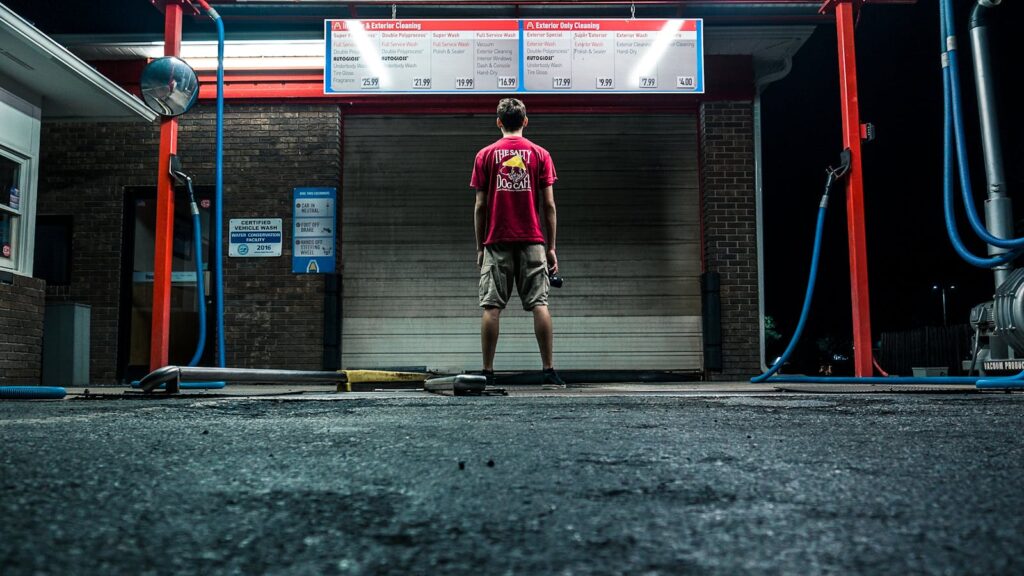 A lone man stands at a car wash at night in Hendersonville, NC.