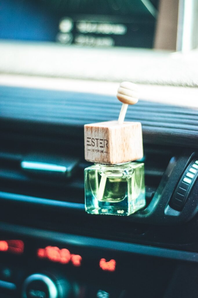 a small bottle of perfume sitting on the dash of a car