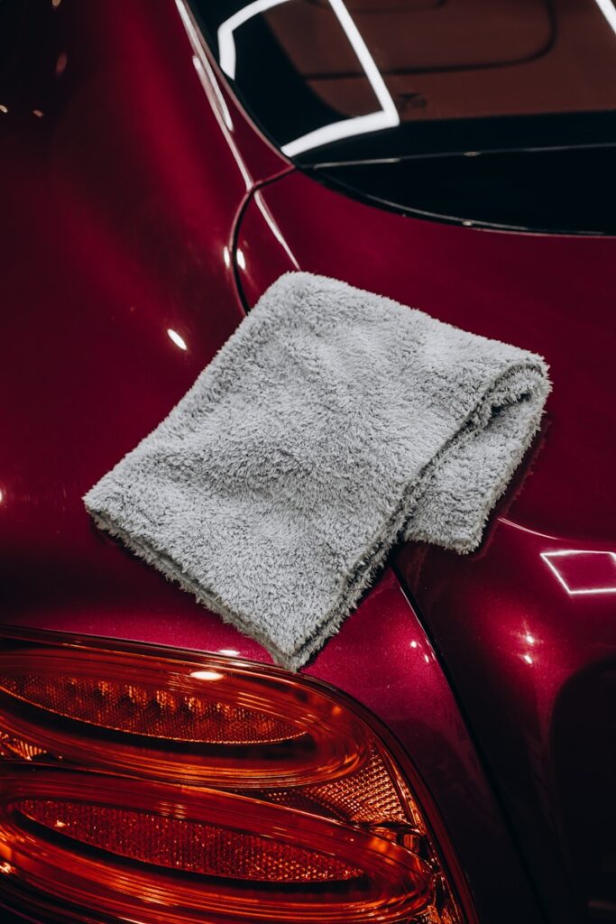 Gray microfiber cloth resting on a red car