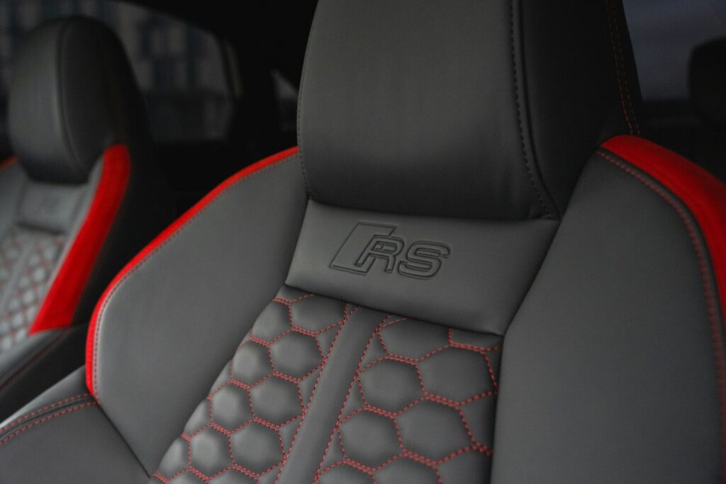 a close up of a car seat with red stitching