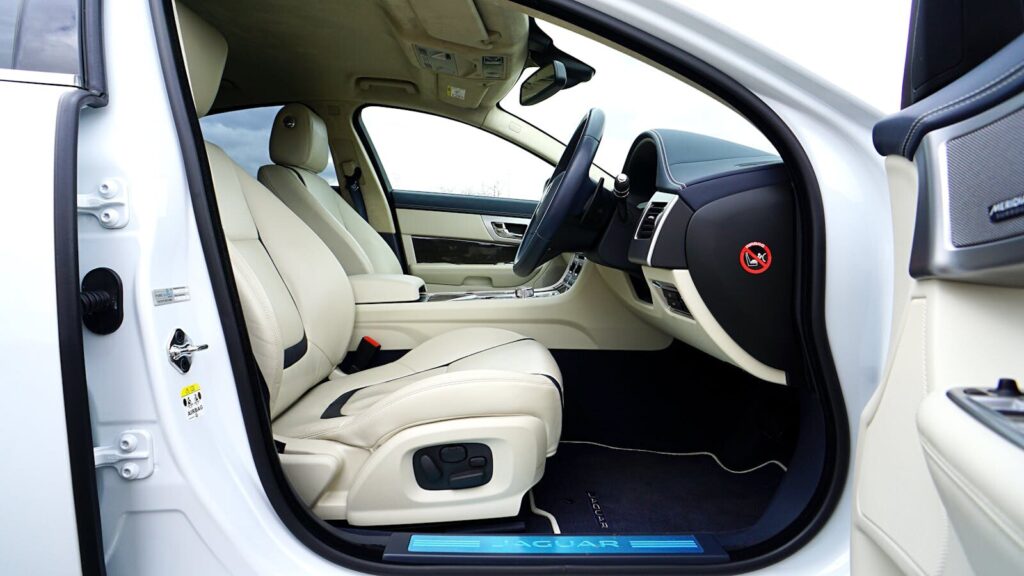 Explore the exquisite leather interior of a Jaguar XF with open doors, showcasing luxury design.