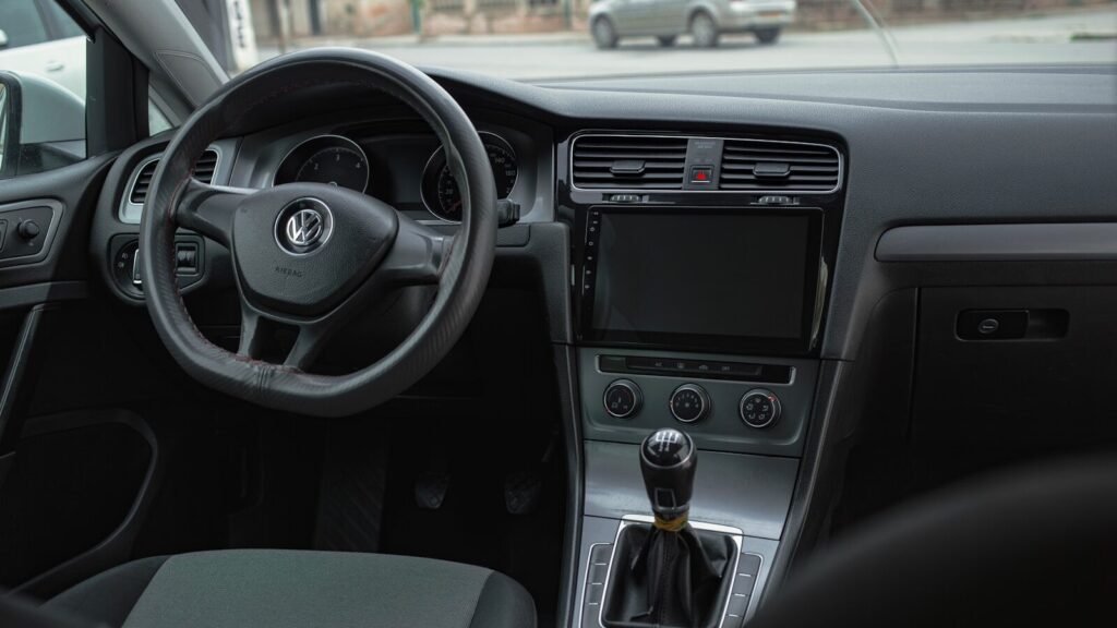the interior of a car with a steering wheel and dashboard