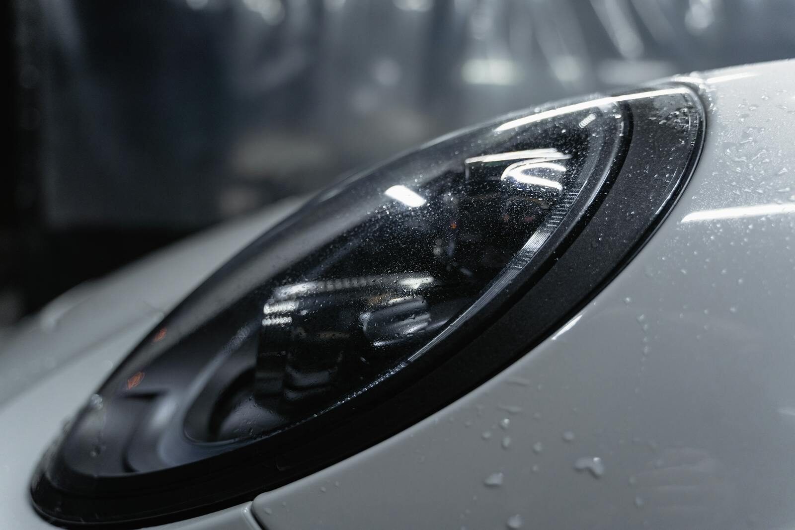 Photo by Tima Miroshnichenko Detailed shot of a sleek car headlight with water droplets enhancing its glossy surface.