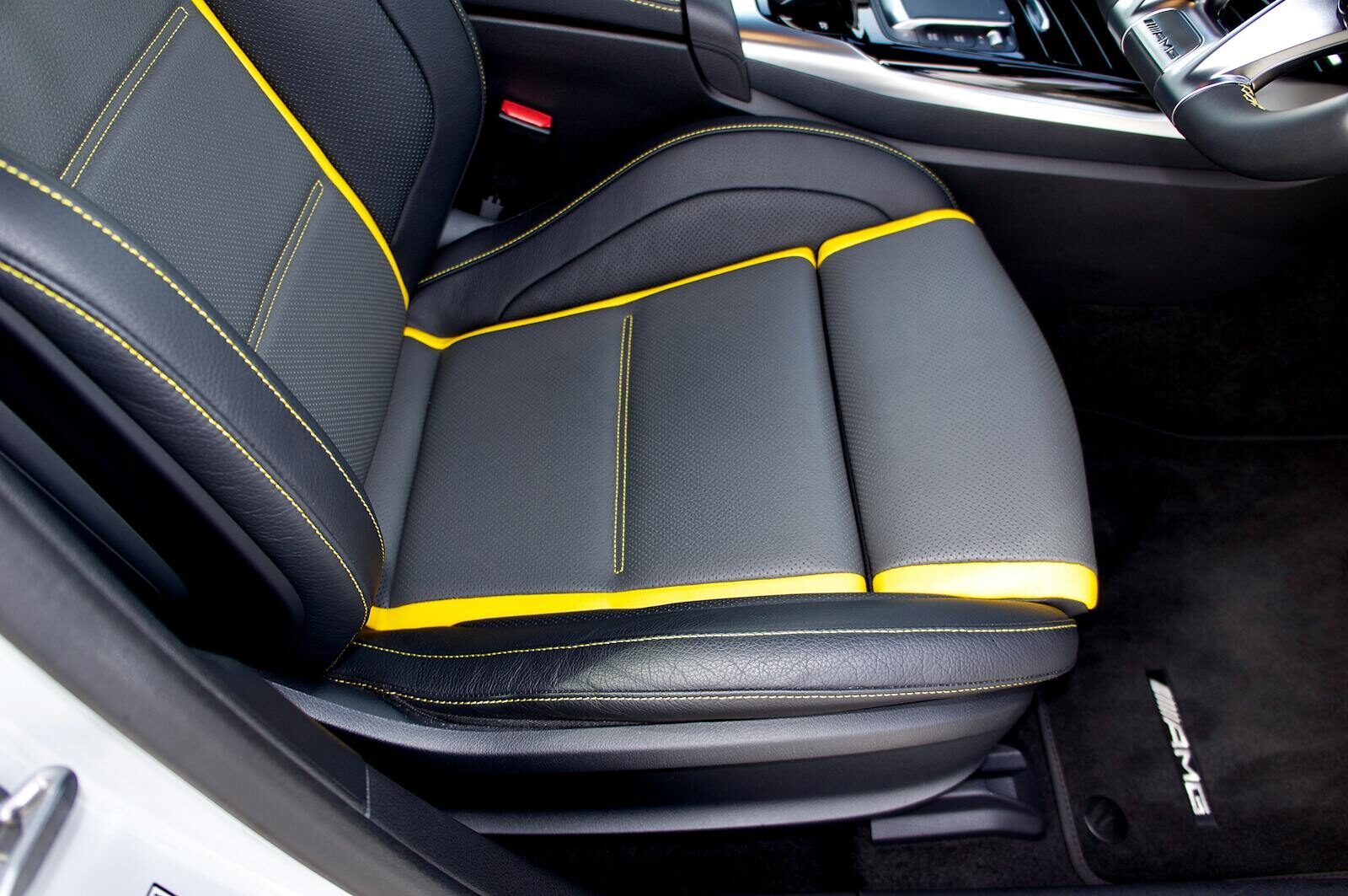 Close-up of a luxury car seat featuring black leather and yellow stitching in the UK.