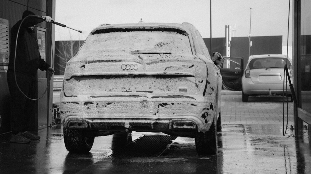 Man washing a car covered in foam