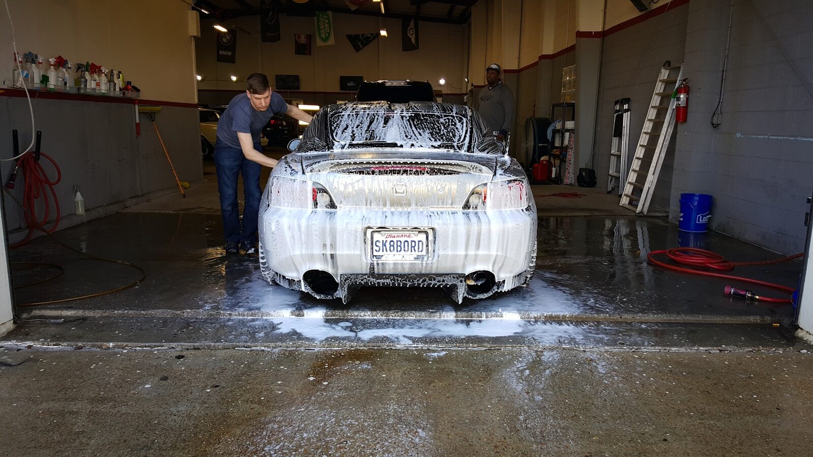 a man washing a car in a garage