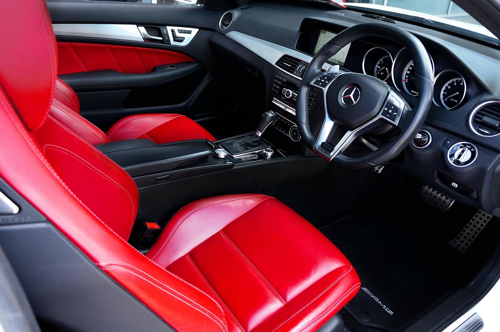 Interior of a luxury Mercedes-Benz car featuring vibrant red leather seats and elegant dashboard design.