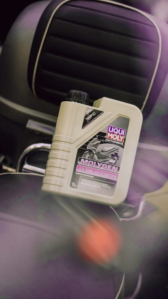 A bottle of oil for a scooter is on a motorcycle.