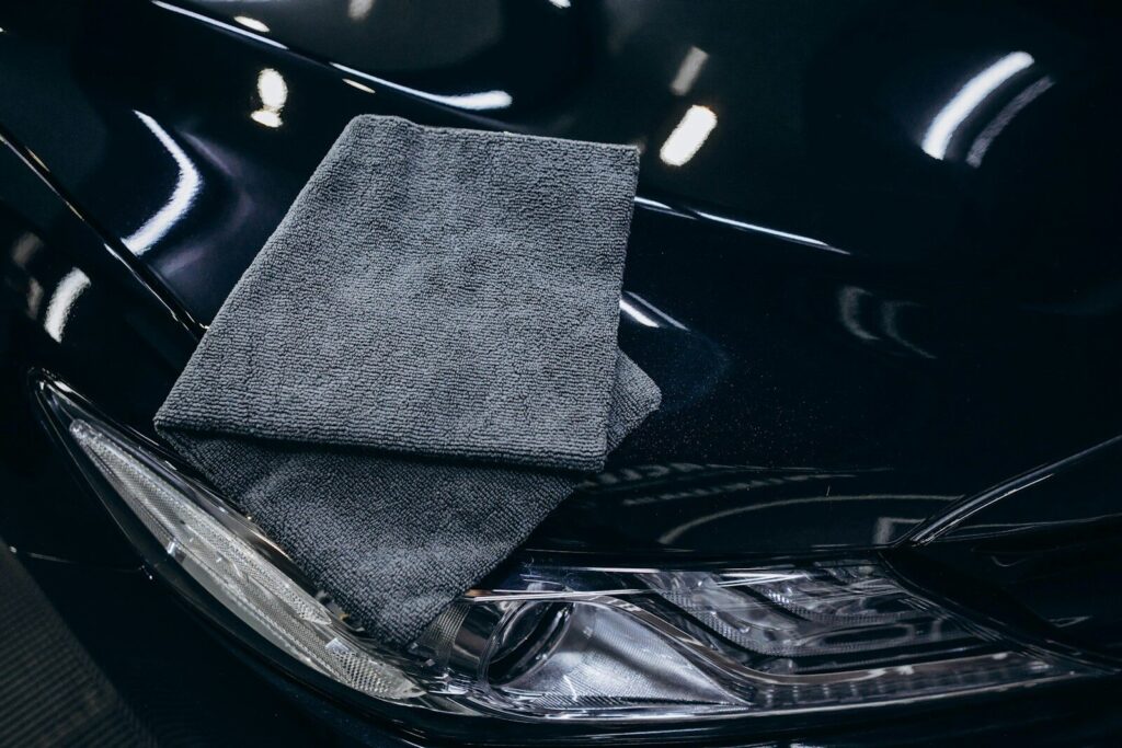 Gray microfiber cloth on a black car hood.