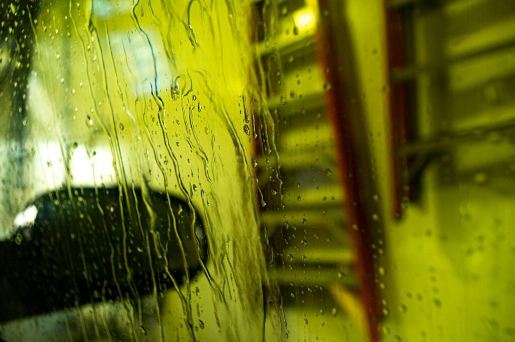 a car is seen through a rain covered window