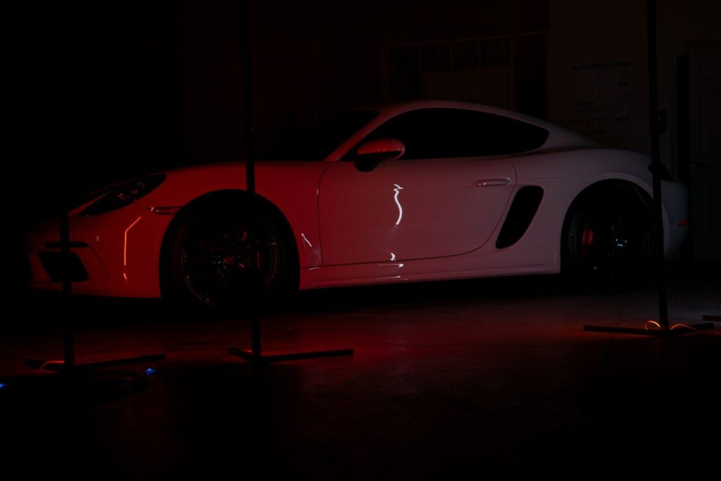 A white sports car parked in a dark garage