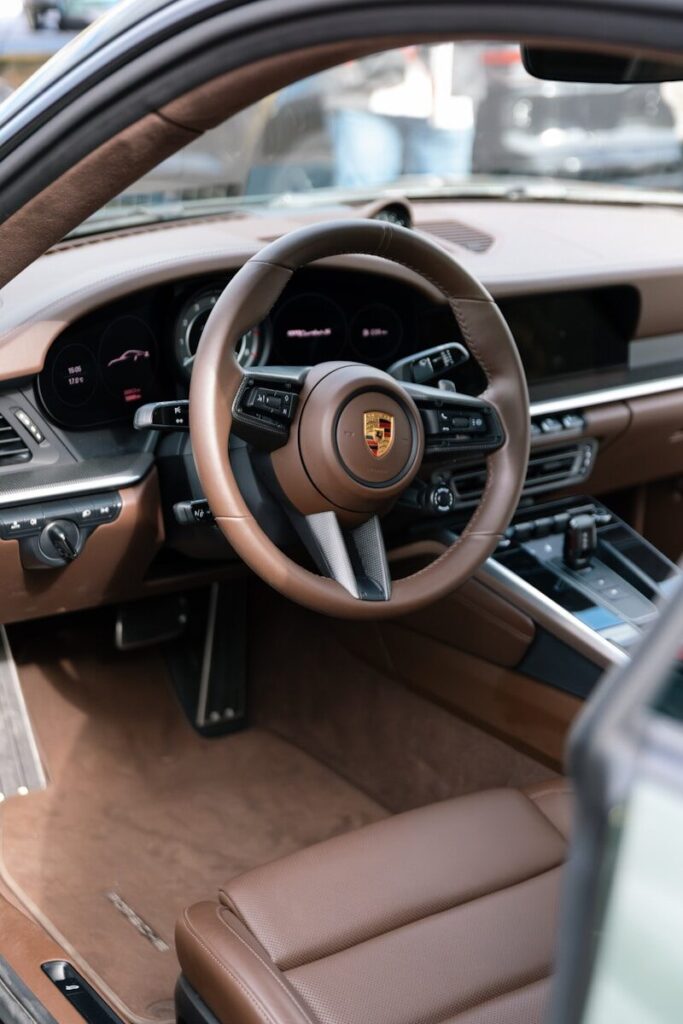 Interior view of a luxurious brown leather car dashboard.