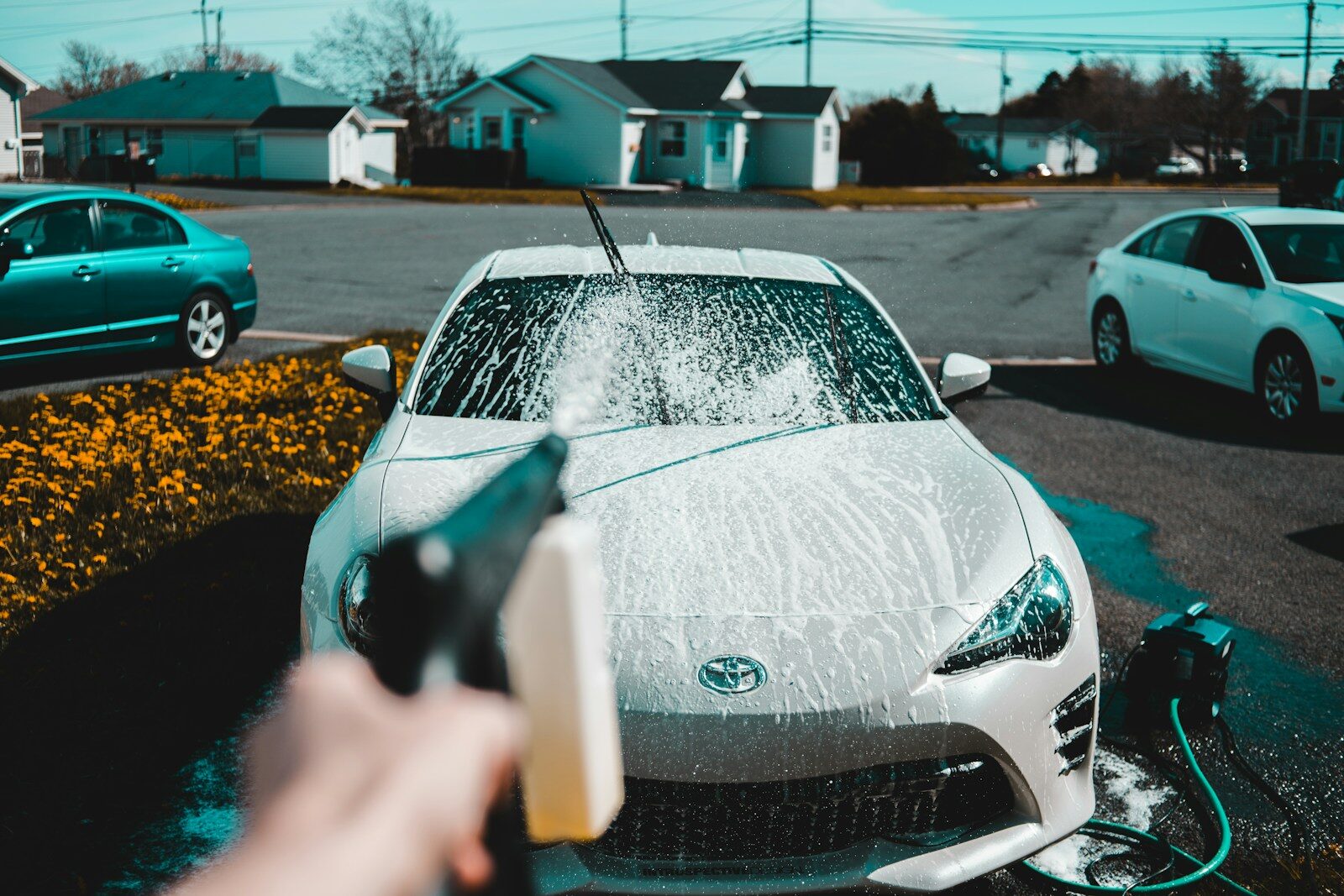 Photo by Erik Mclean person spraying water on vehicle