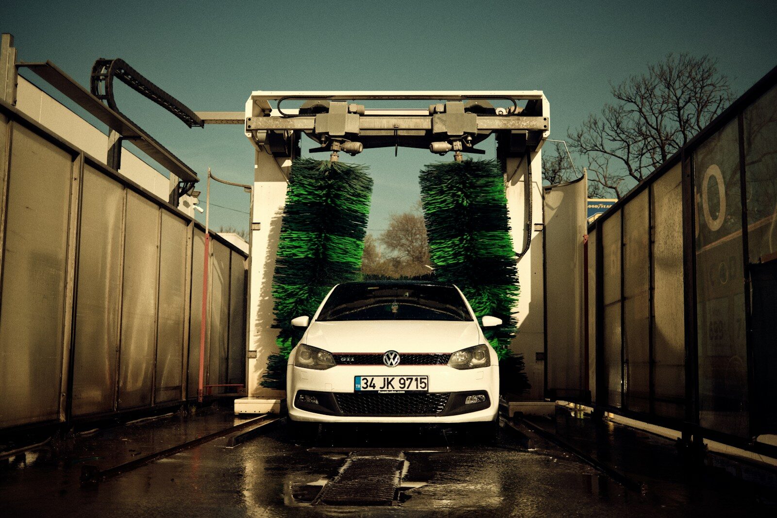Photo by Gökhan Topel a white car parked in front of a gate