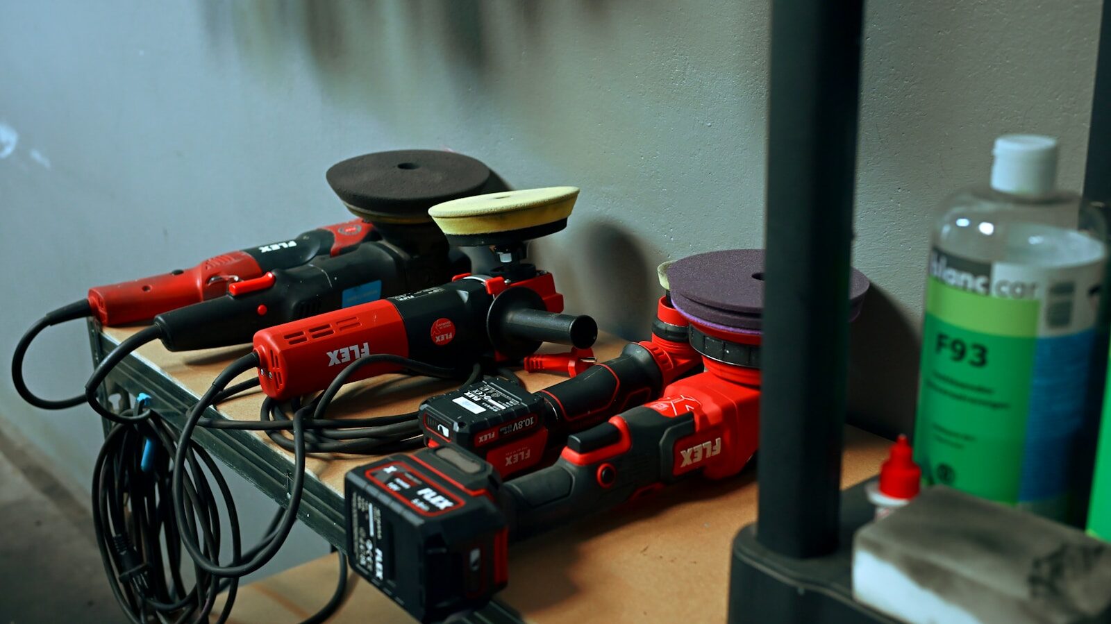 Photo by Luay Barani Several red car polishing tools on a shelf.
