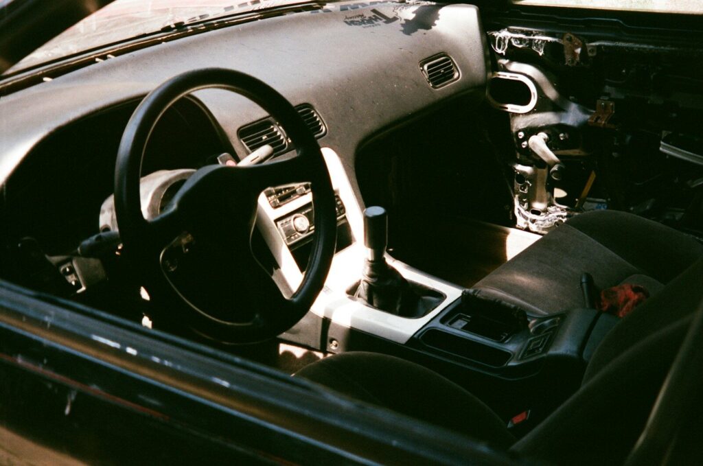 The interior of a car with a steering wheel and dashboard