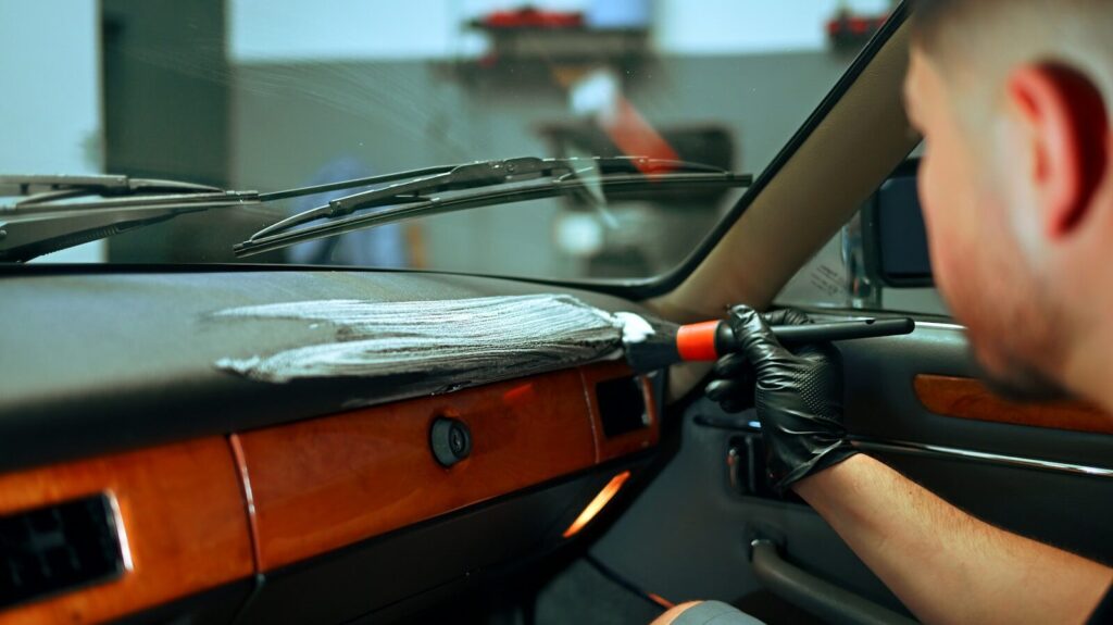 Man cleaning car dashboard with brush