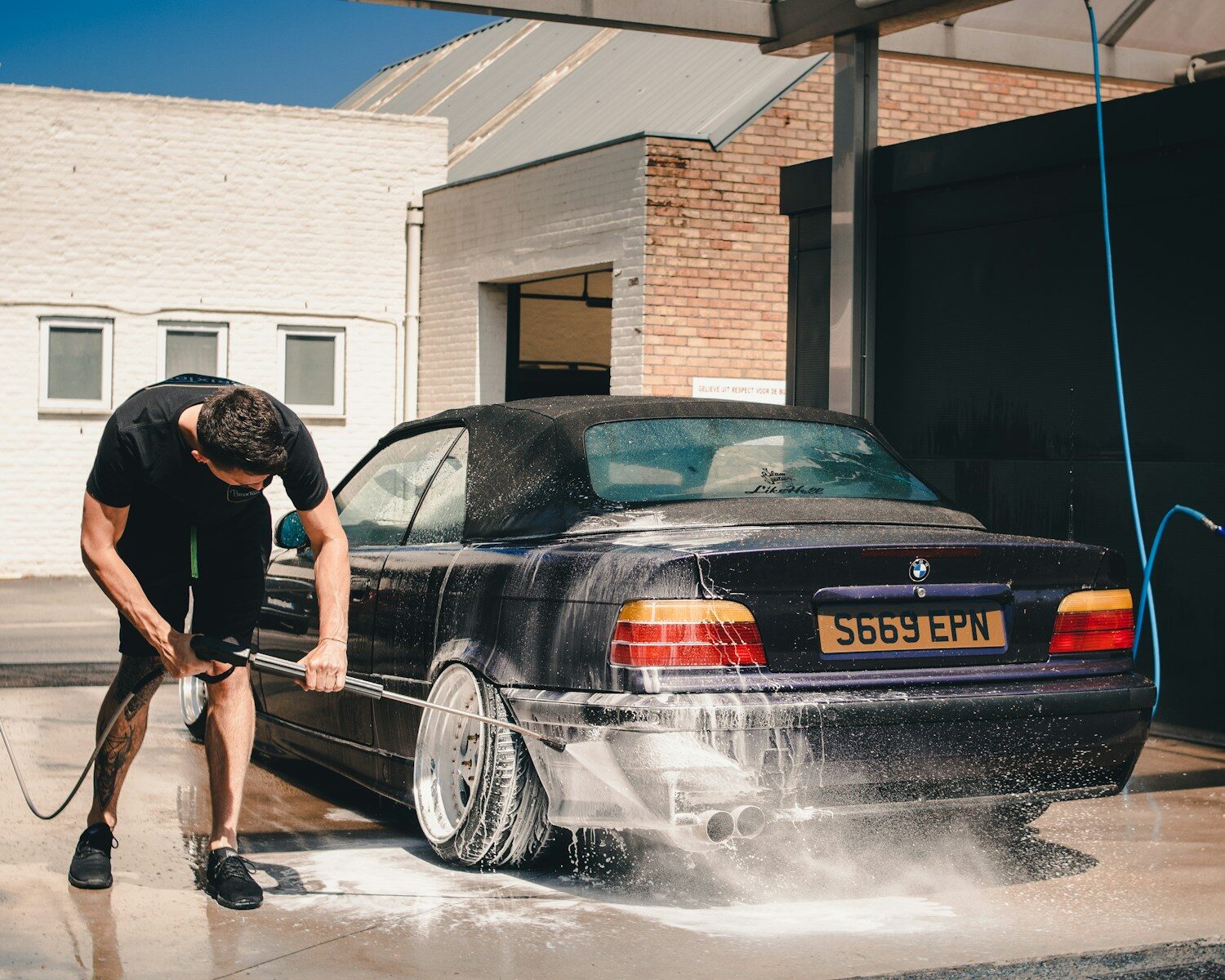 Photo by Ethan Sexton man washing BMW coupe