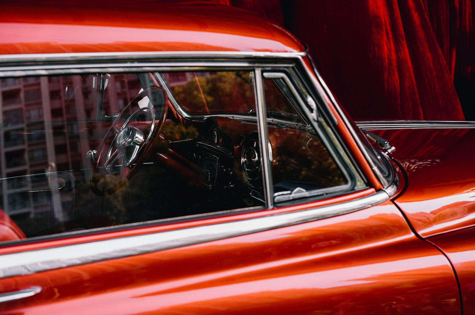 a red car parked in front of a tall building