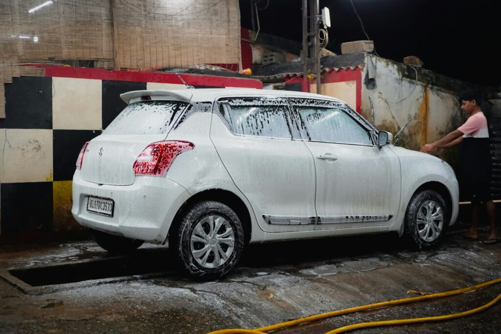 Man washing a white car covered in soap