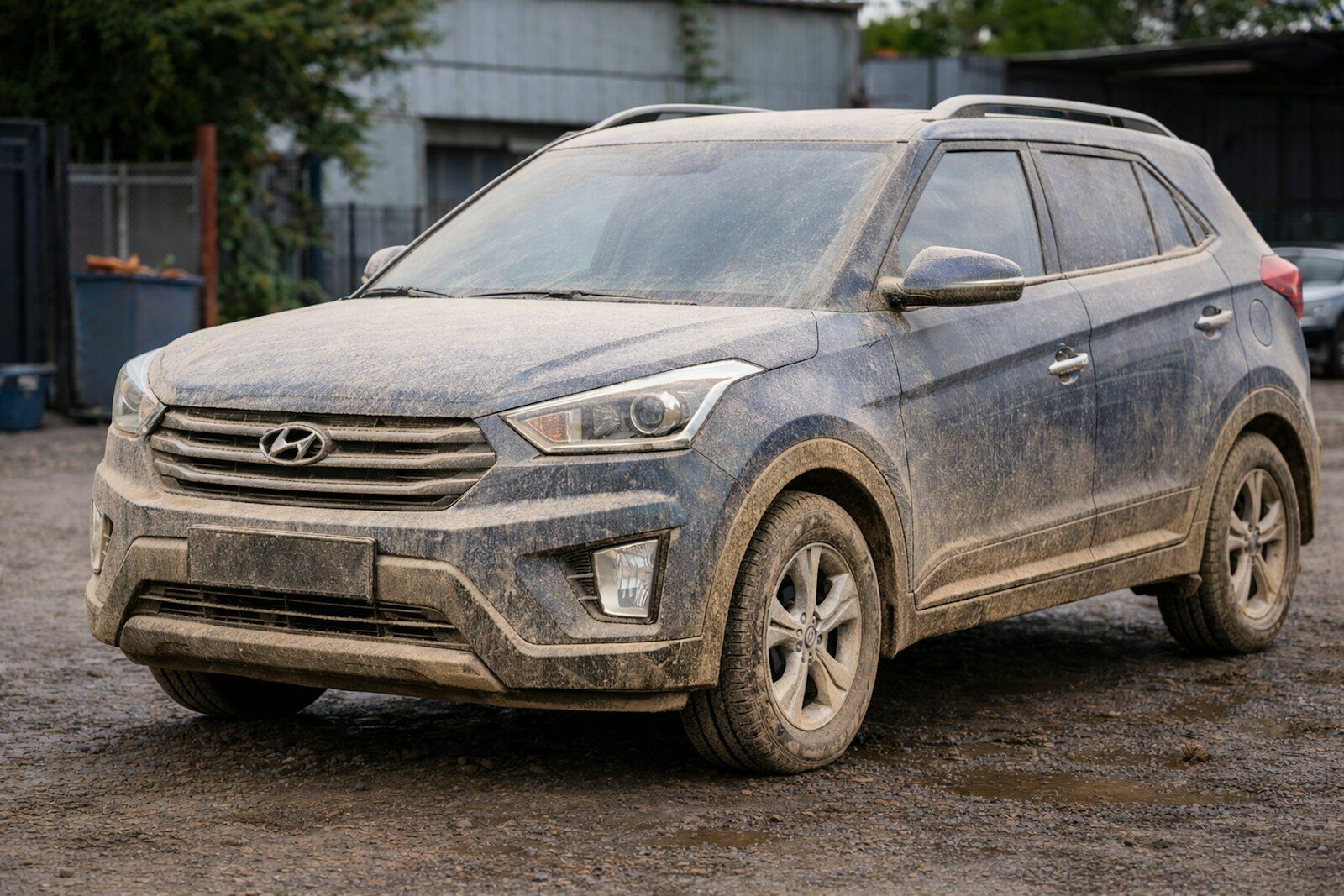 Photo by Dany Caiza A dirty dark blue suv parked on a muddy road