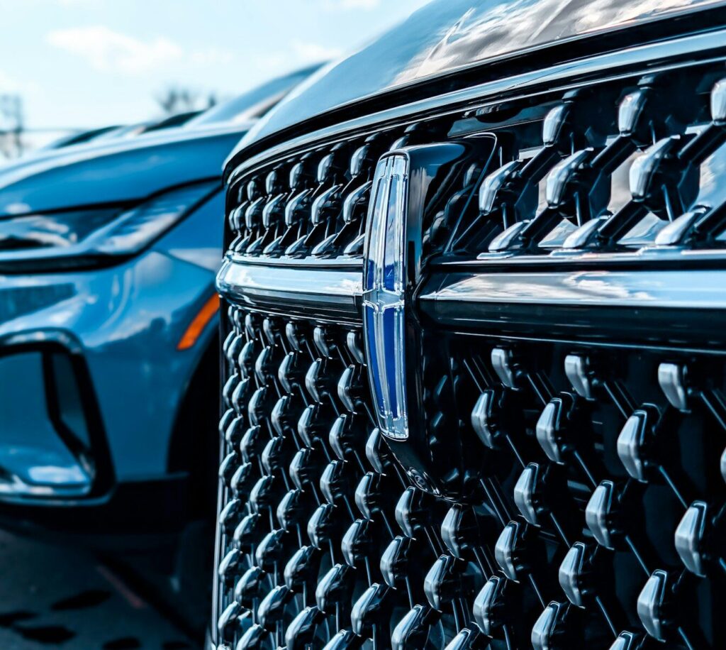 Close-up of a shiny car grille with emblem.