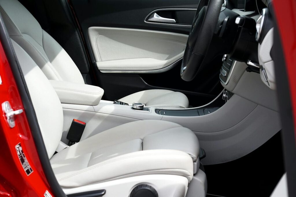 Explore the elegant design of a luxury car interior featuring pristine white leather seats and a sleek red exterior.